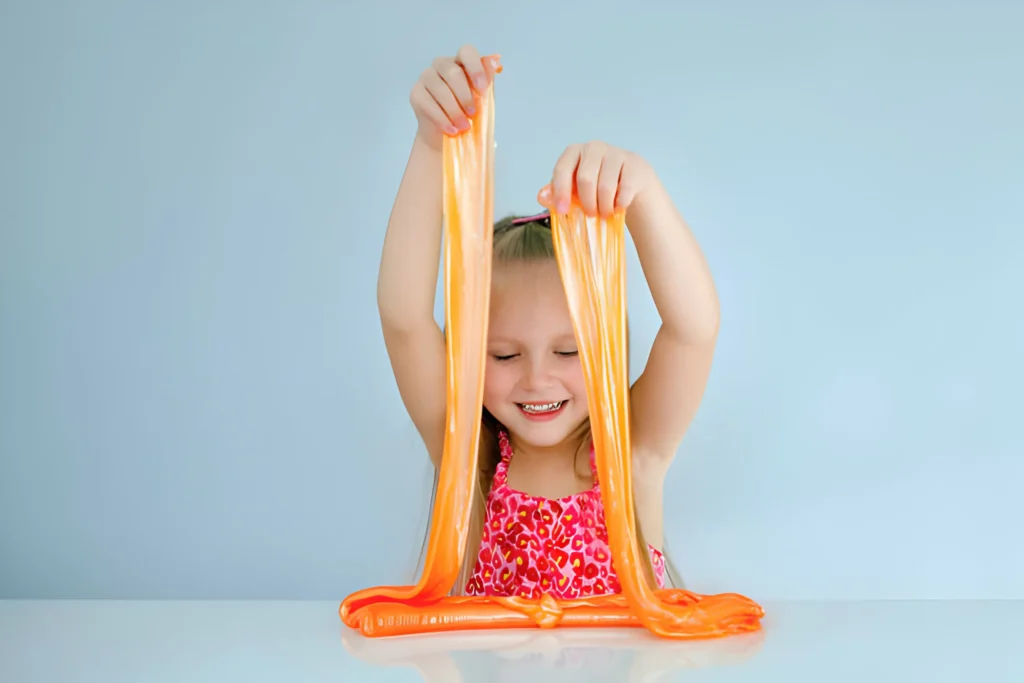 Cute funny girl play with orange slime