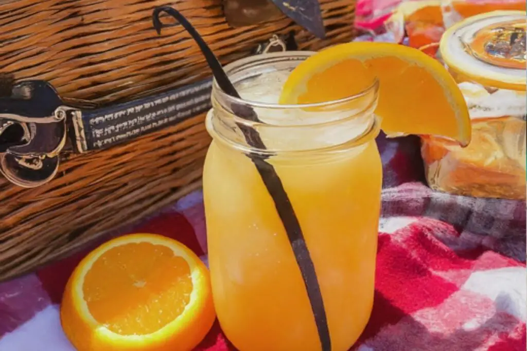 Orange Dreamsicle Moonshine in a mason jar with orange slice and vanilla bean.