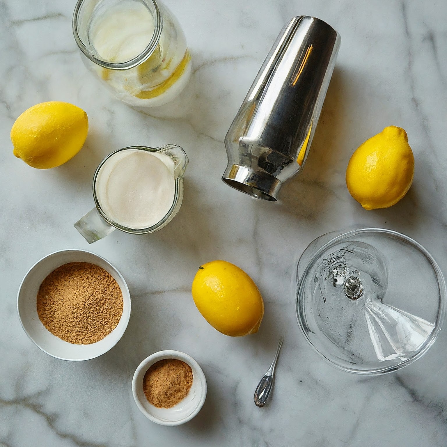Overhead view of Lemon Meringue Martini ingredients on marble countertop.